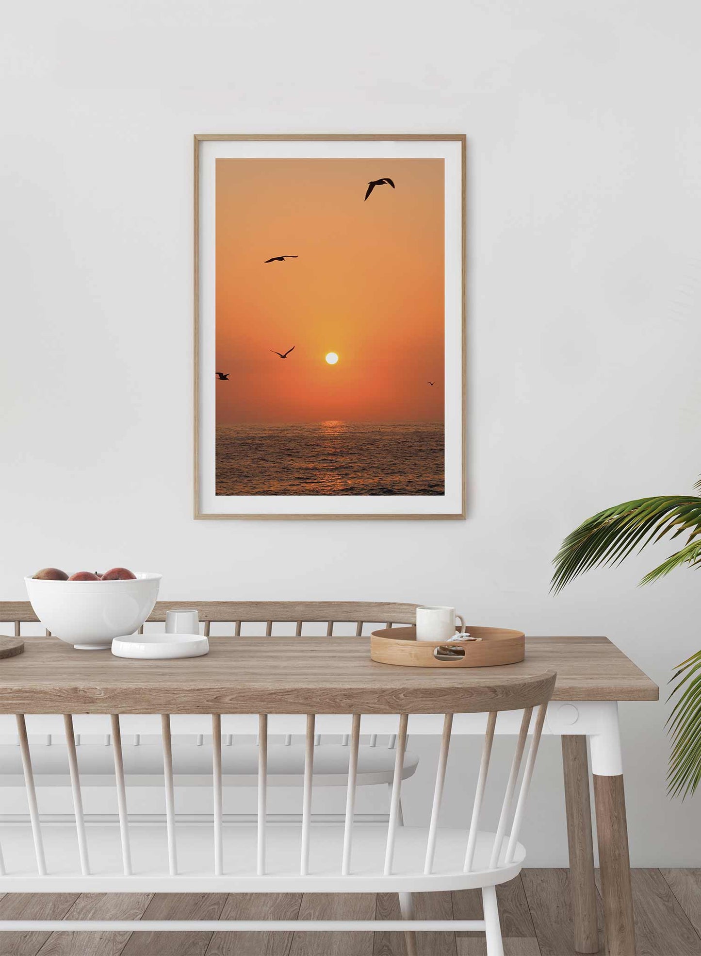 Flying into the Sunset is a minimalist photography of a scenery where three birds are flying above the sea as the orange sun sets by Opposite Wall.