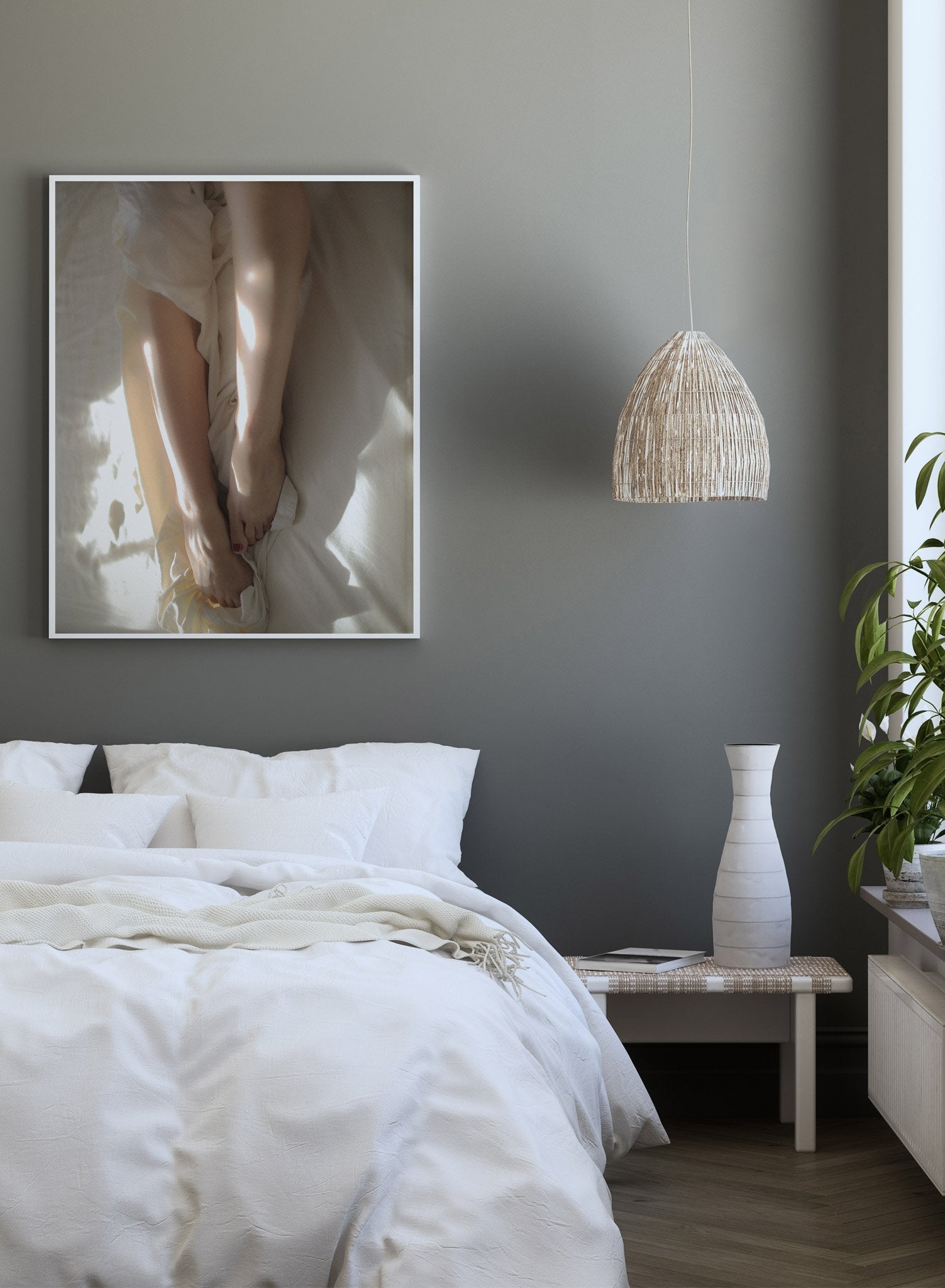 "Between the Sheets" is a minimalist beige and white photography poster by Opposite Wall of a woman’s nude legs, and feet in white bed sheets.