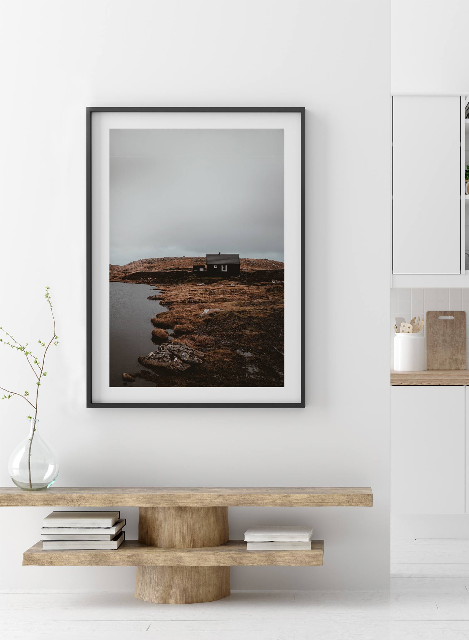 Lakeside View' is a landscape photography poster by Opposite Wall of a quaint cottage style house on orange and brown grass overlooking a quiet lake under a cloudy grey sky.