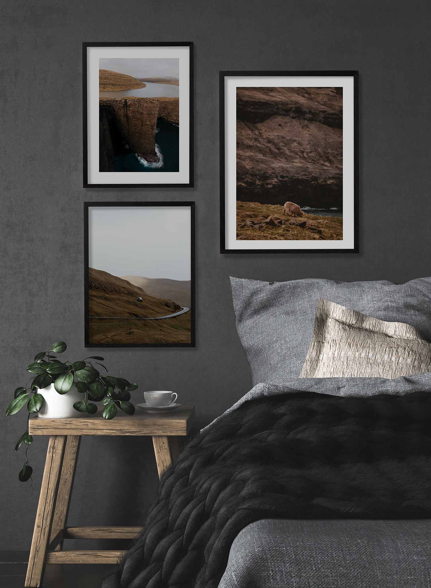 Wandering Sheep' is a landscape photography poster by Opposite Wall of a lone white sheep wandering in green grass by a river and a tall rocky cliff.